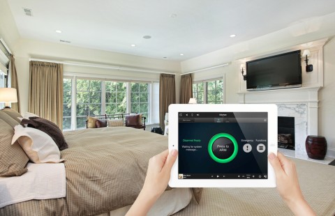 A Control4 home automation iPad interface for arming the security system with a master bedroom in the background.