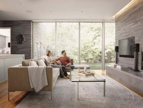 A couple is sitting in their living room in a Savant-controlled home.