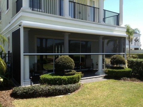 A home’s exterior showing shading from Progressive Screens lowered around a patio area.