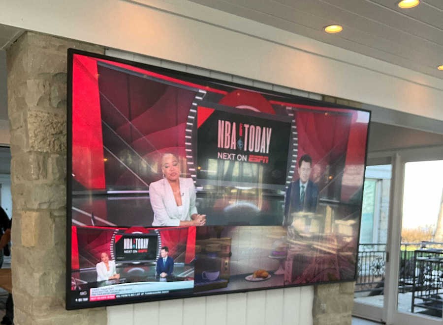 A 100-inch TV mounted in a media area showing the scale and impact of large-format displays.