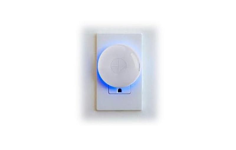 Hunter Douglas PowerView controller plugged into an outlet with a glowing blue light.