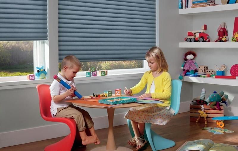 Children playing in a nursery with Hunter Douglas PowerView shades in the background.