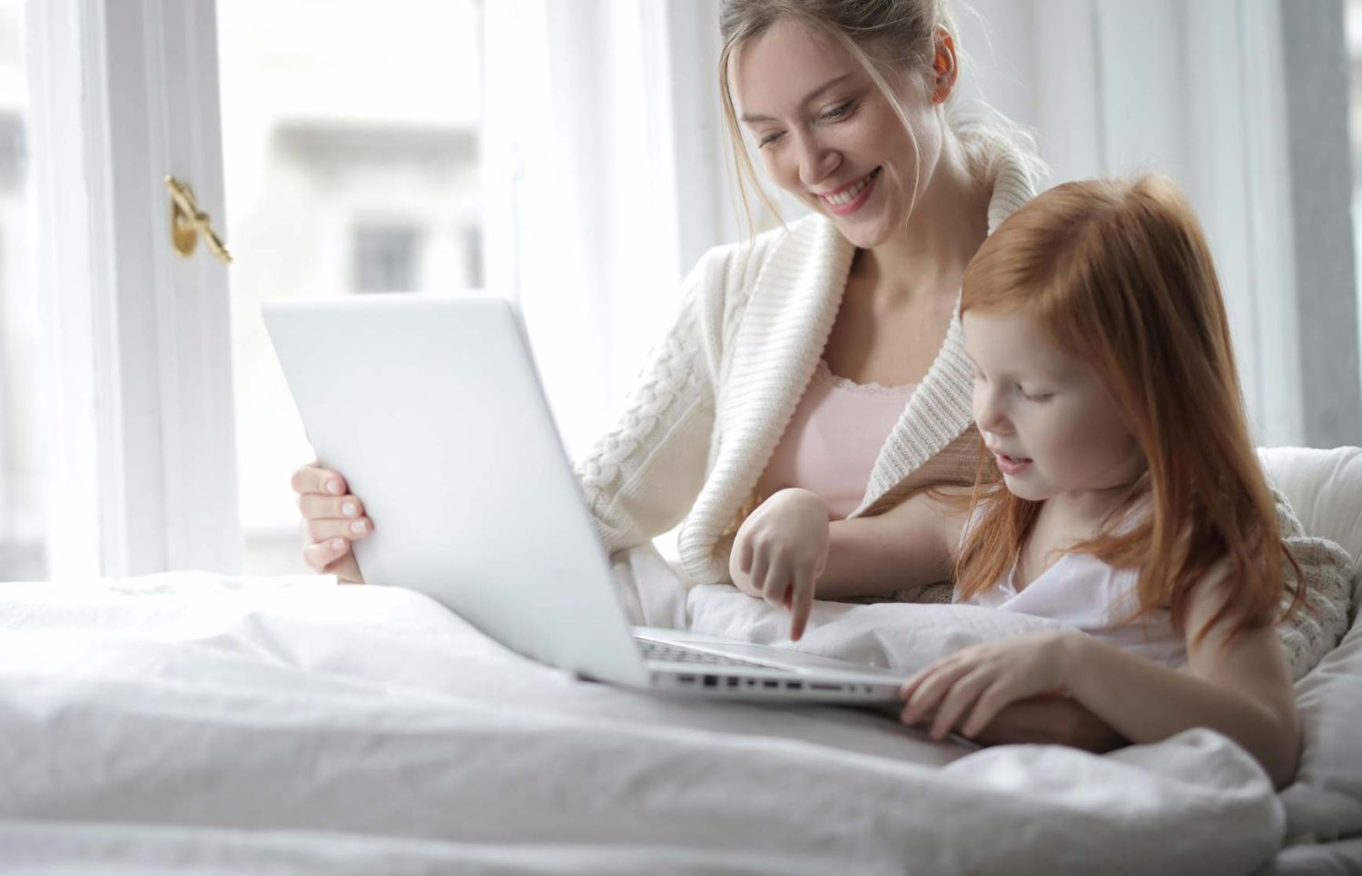 mom and daughter playing on laptop together