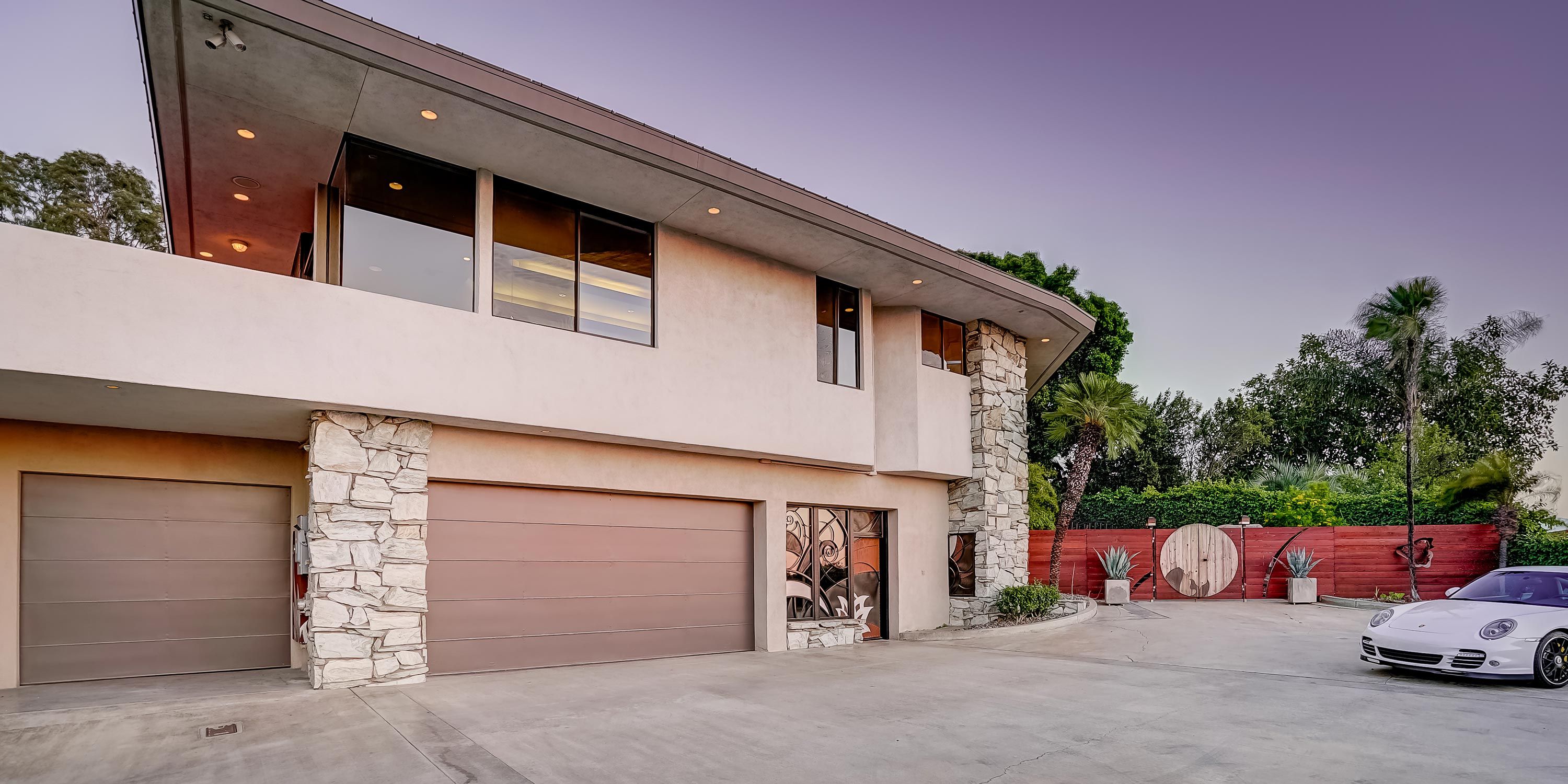 A stylish gated entry with a contemporary home featuring large windows.